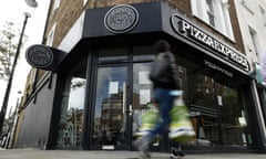 A pedestrian walks past a closed branch of Pizza Express in London.