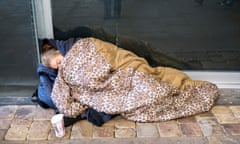 A homeless woman sleeps rough on Market St. Manchester, UK.