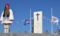 Military personnel in traditional dress in front of a cenotaph