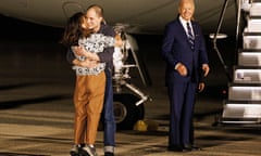 Evan Gershkovich hugs family members as President Joe Biden looks on next to aeroplane steps