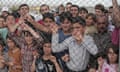 Syrian refugees stand behind a fence at a camp in Turkey