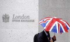 A worker shelters from the rain as he passes the London Stock Exchange in London