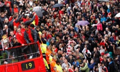 Manchester United fans line the city’s rain-soaked streets to cheer their team during a parade of the Premier League trophy. The bus bears the number 19 to mark the number of times the club has won the title.