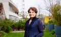 Elaine Bedell stands in a small garden on the South Bank, with the Centre and the London Eye ferris wheel visible in the background behind her