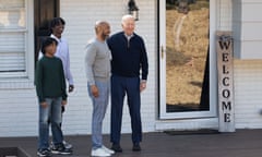 joe biden with a family outside a house with a sign that says 'welcome'