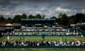 Spectators watch a single's match on an outer court at Wimbledon