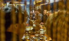 Patrons gather around a small yakitori stand in Omoide Yokocho, Shinjuku, Tokyo.