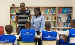 Two adults teach four children in a classroom.