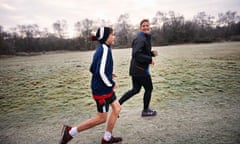 Side view of mother and son running on grassland smiling