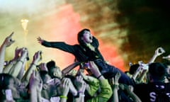 people celebrate at a concert, with one person crowdsurfing