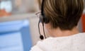 A woman at a computer wearing a phone headset