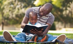 Father reading with son (4-5) on lawn