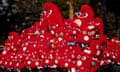 Red plush Paris 2024 mascots cover a car.