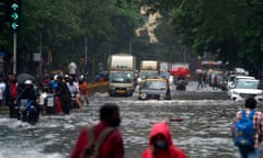 Commuters make their way through a flooded road following heavy monsoon rains in Mumbai.