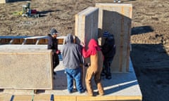 Men standing on a platform lowering a wall panel