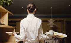 Waitress carrying dirty plates in restaurant, rear view