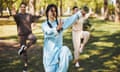 Tai chi trainer standing in crane pose before two students