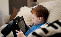 a boy reads from a digital tablet.