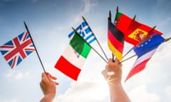 A person holds European country flags in an hand and a United Kingdom flag in another