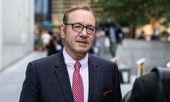 Kevin Spacey arrives at Southwark crown court on 26 July 2023, wearing dark blue suit, white shirt, red tie and glasses