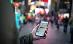 Man using Uber app on iPhone in Times Square