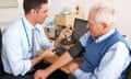 A GP measures a man's blood pressure in his surgery.