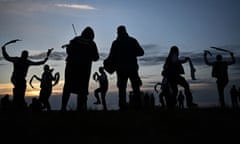 Silhouettes of morris dancers on a blue and pink sky