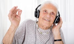 An older woman listening to headphones