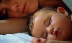 Mother and baby sleep in bed together