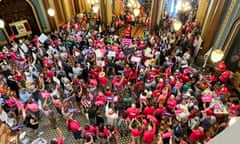 People wearing mostly hot pink shirts protest inside a state building