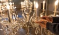 Close-up of ornate chandelier with person's hands in shot