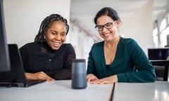 Female colleagues using a virtual assistant on an office table