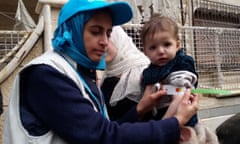 Unicef employee measures the arm of a malnourished child in the besieged Syrian town of Madaya