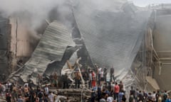 People gathered around the collapsed roof and rubble of the children's hospital in Kyiv