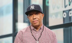 Man with blue cap wearing red checkered buttondown and necklace.