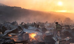 A firefighter removes the remains of a burned house on a hill, where more than 100 homes were burned due to forest fire but there have been no reports of death, local authorities said in Valparaiso, Chile January 2, 2017.