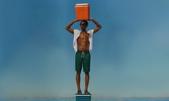 Model standing on an cooler holding a cooler above head