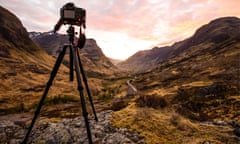 Photographer set up the tripod for the sunset on mountains peak in Glencoe, Scotland, UK.