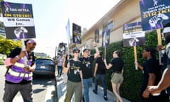 people wearing black shirts hold protest signs in front of a building