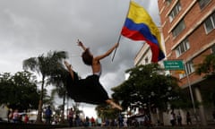A ballet dancer holding a flag mid-leap at a protest in Cali, Columbia