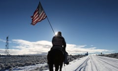 Duane Ehmer carries an American flag as he rides his horse, Hellboy, at the occupied Malheur National Wildlife Refuge on January 15, 2016 near Burns, Oregon.