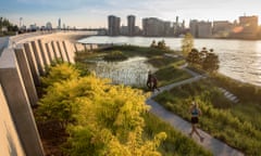 View of Hunter's Point South waterfront park at sunset with a woman running through