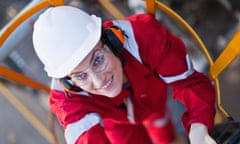 Worker climbing ladder at oil refineryWorker climbing ladder at oil refinery