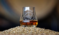 an In The Wind glass of whisky sits atop a pile of barley