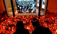 A couple light a candle at a temporary memorial to the Velvet Revolution.