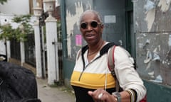 Black woman wearing round sunglasses and looking straight at camera