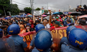 Demonstrators blocked by police in helmets in Quezon City, Philippines