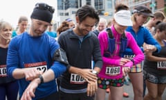 Marathon runners prepare their smartwatches at the start of a race