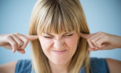 A woman blocking her ears with her fingers