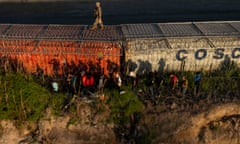 A national guardsman patrols the US-Mexico border atop a shipping container.